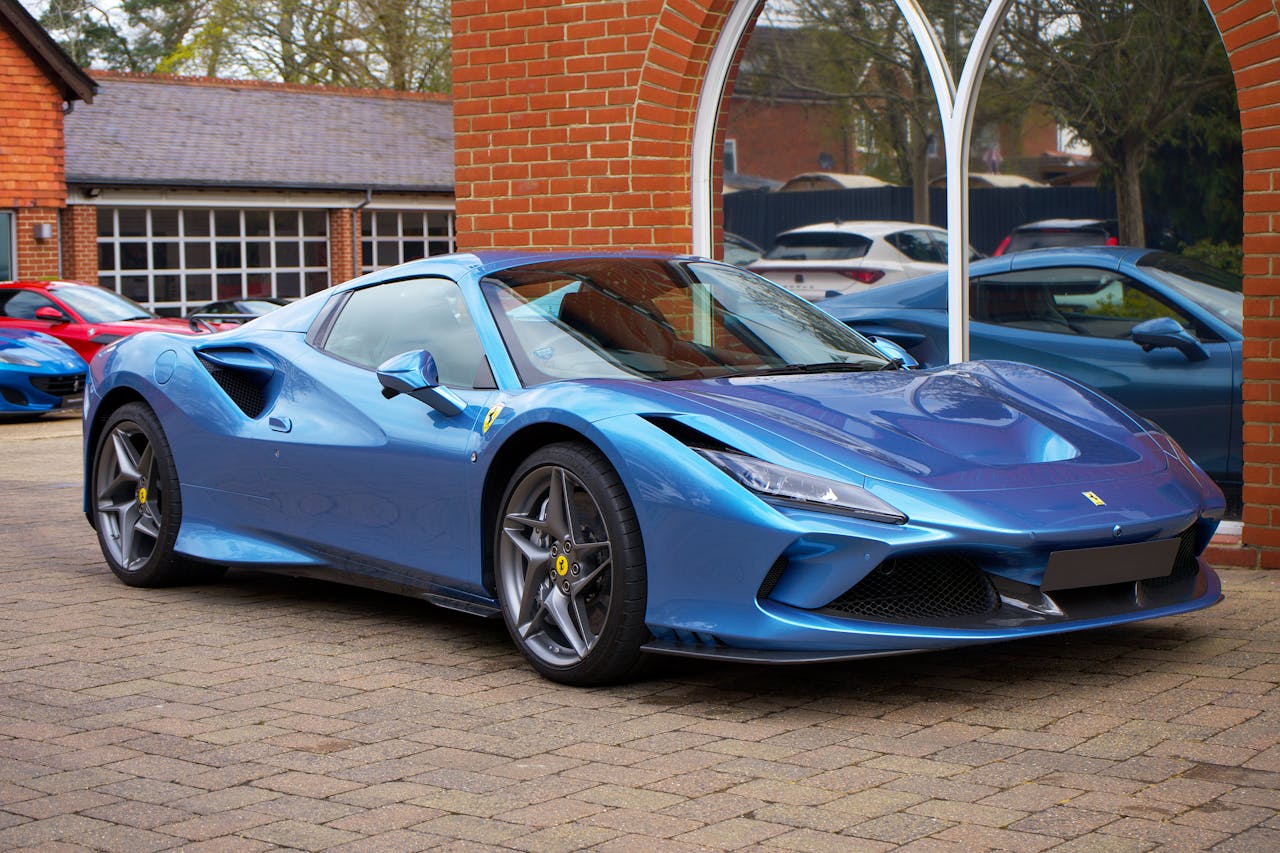 A modern blue sports car parked outdoors in an urban environment.